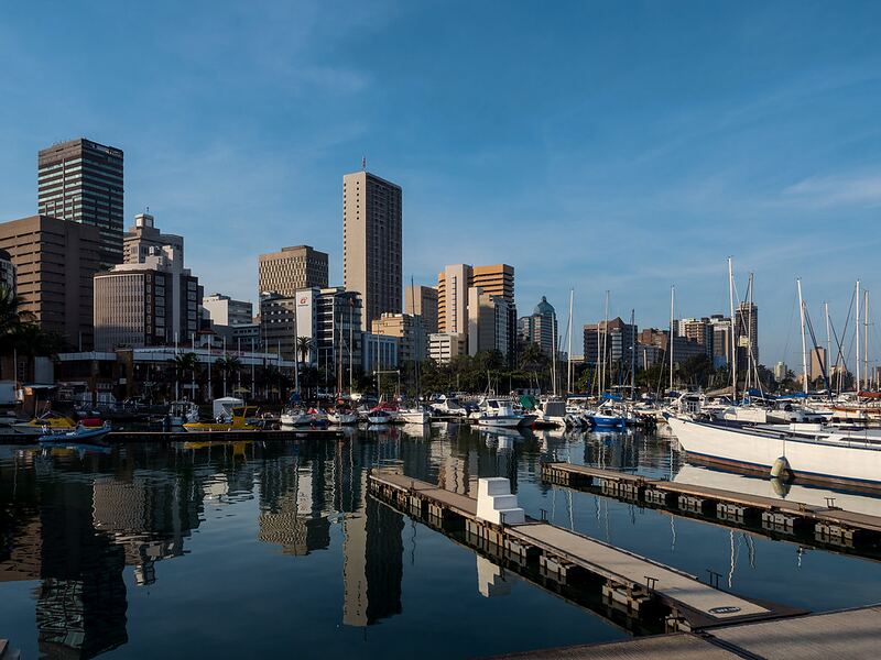 Boats moored in Durban Harbour with the city buildings behind them