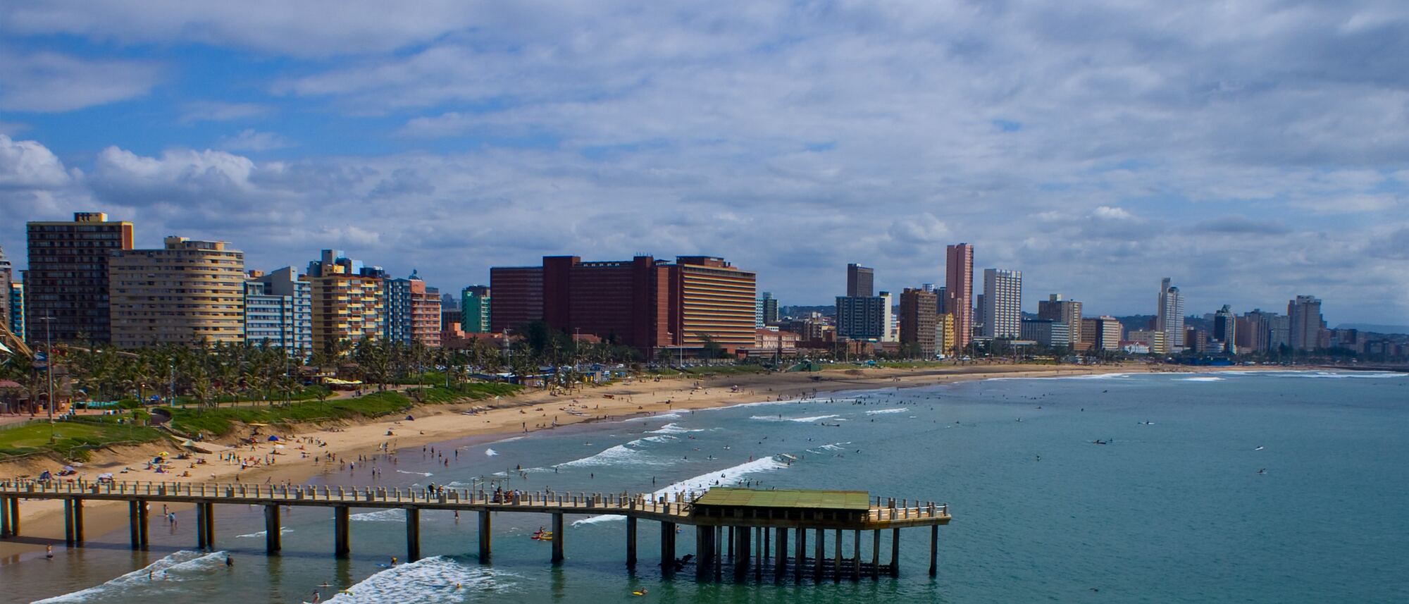 Wide view of Durban beach, the pier and the city skyline behind the sand